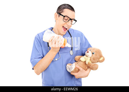 Médecin homme stupide à un lait alimentation ours isolé sur fond blanc Banque D'Images