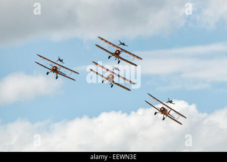 Quatre biplans Boeing Stearman du Breitling Wingwalking AeroSuperBatics Team faire un col à la RAF Fairford Air Tattoo Banque D'Images