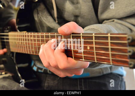 Jouant sur le manche de guitare sur une guitare électrique Banque D'Images