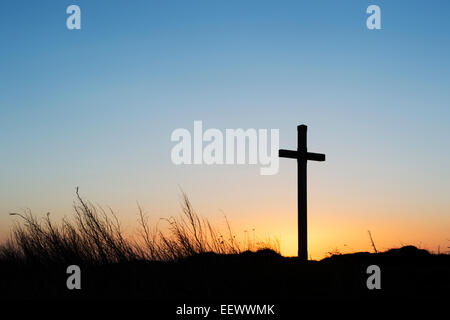 St Cuthbert's Isle croix de bois sur l'Île Sainte de Lindisfarne, au lever du soleil. Northumberland, Angleterre. Silhouette Banque D'Images