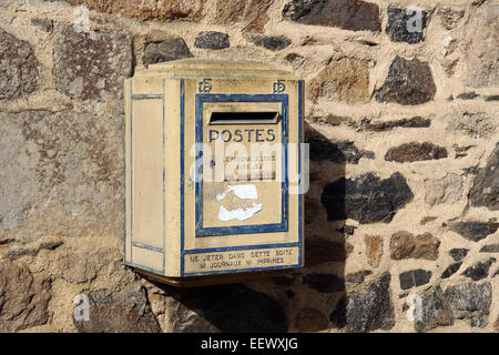 Vieux Français jaune postbox accroché sur un mur en Bretagne, France Banque D'Images