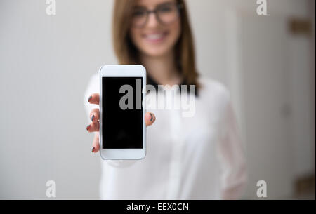 Businesswoman showing un blanc de l'écran du smartphone. L'accent sur le smartphone. Banque D'Images