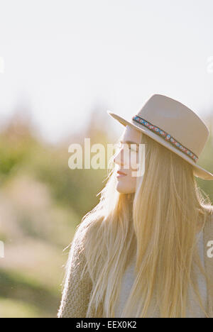 Femme avec de longs cheveux blonds, portant un chapeau. Banque D'Images