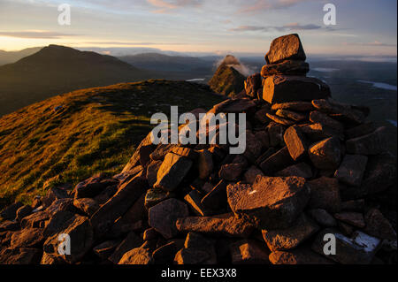 Vue d'un cairn au sommet de la montagne Suilven au lever du soleil, Ecosse, Royaume-Uni. Banque D'Images