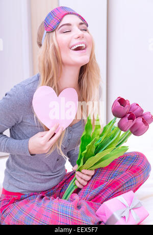 Portrait of cute femme excité avec lettre romantique et rire avec les yeux clos, éveillé et surpris de doux cadeau romantique Banque D'Images