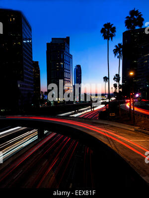 Une scène de nuit d'une autoroute de Los Angeles avec des immeubles à l'arrière-plan prendre au cours de l'heure bleue. Banque D'Images