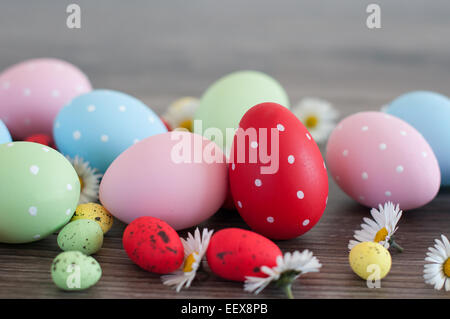 Autre couleur les oeufs de Pâques sur un vieux bois et fleurs de printemps Banque D'Images