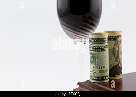 La devise américaine placé sur bois poli située en face du verre de la tige avec du vin rouge ; horizontal image avec l'espace blanc. Banque D'Images