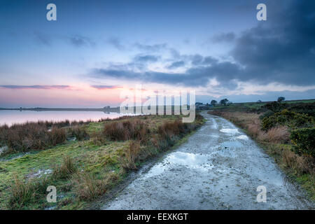 La nuit tombe sur chalets niché au bord de l'eau à Dozmary pool près de Bolventor sur Bodmin Moor en Cornouailles Banque D'Images