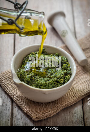 Pesto de basilic maison sur une table en bois. Banque D'Images