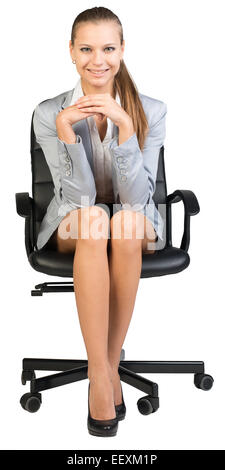 Businesswoman on office chair, avec les mains jointes sous son menton Banque D'Images