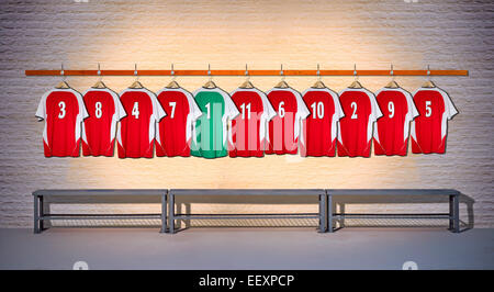 Ligne de maillots de football rouge pendaison au vestiaire. Banque D'Images