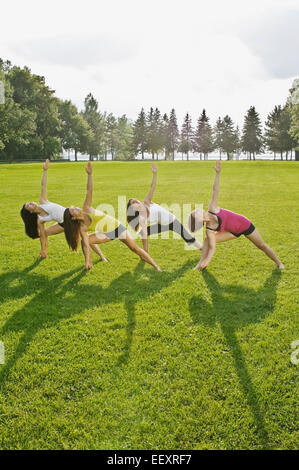 Quatre femmes faisant du yoga dans un parc Banque D'Images