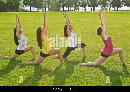 Quatre femmes faisant du yoga dans un parc Banque D'Images