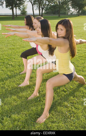 Quatre femmes faisant du yoga dans un parc Banque D'Images