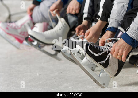 Le laçage des patins à l'extérieur de la famille Banque D'Images