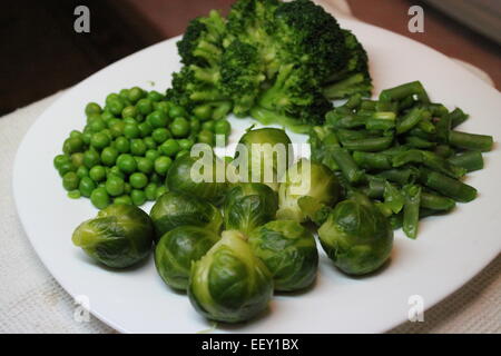 Les légumes verts frais appétissant le brocoli, choux de Bruxelles, haricot, pois jeter sur la plaque Banque D'Images