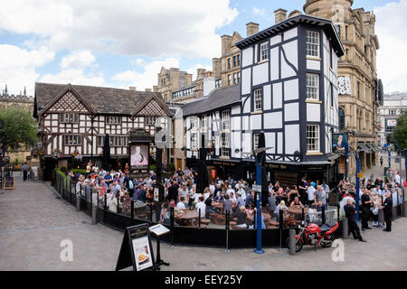 Occupé à colombages du 16ème siècle l'ancienne auberge 1552 Wellington pub urbain avec une foule de personnes en plein air. Manchester, Angleterre, Royaume-Uni, Angleterre Banque D'Images