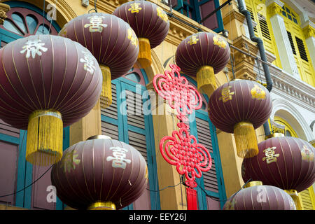 Lanternes décoration scénique pendu sur la construction de murs colorés dans le quartier chinois de Singapour Banque D'Images