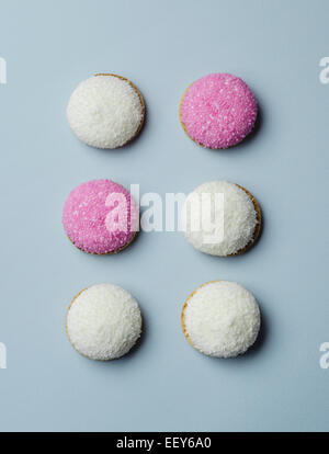 Biscuits de guimauve et de noix de coco sucre rose saupoudre sur fond bleu, voir ci-dessus Banque D'Images