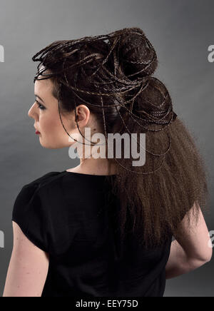 Vue latérale du portrait d'une jeune femme avec une coiffure élaborée avec tresses et cheveux ondulés Banque D'Images