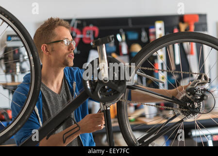 La réparation de l'homme en vélo shop Banque D'Images