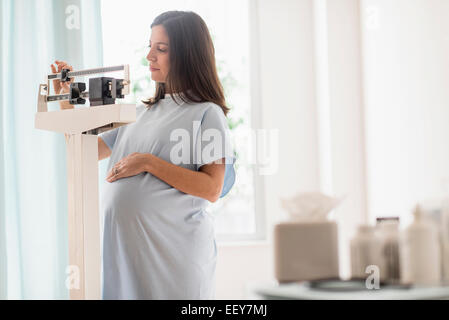 Femme enceinte sur l'échelle au cabinet du médecin Banque D'Images