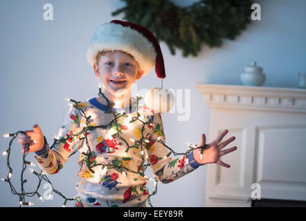 Portrait of boy (6-7) holding christmas lights Banque D'Images