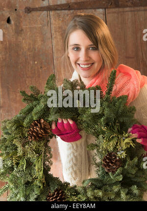 Portrait de jeune femme avec couronne de Noël dans les mains Banque D'Images