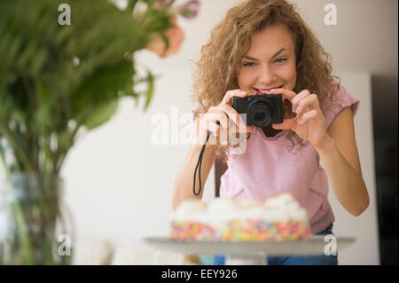 Young woman photographing gâteau d'anniversaire Banque D'Images