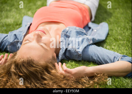 Young woman lying on lawn Banque D'Images