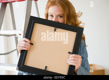 Portrait of woman holding photo frame Banque D'Images