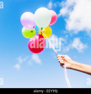 Young man holding balloons Banque D'Images