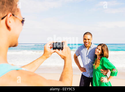 USA, Floride, Jupiter, jeune homme de prendre photo de couple on beach Banque D'Images