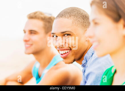 Portrait of young man smiling in entre amis de flou artistique Banque D'Images