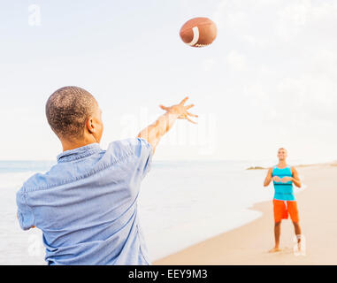 USA, Floride, Jupiter, les jeunes hommes jouent au football sur la plage Banque D'Images