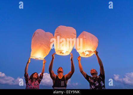 Les jeunes avec des lanternes illuminées au coucher du soleil Banque D'Images