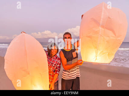 Les jeunes avec des lanternes illuminées sur la plage Banque D'Images