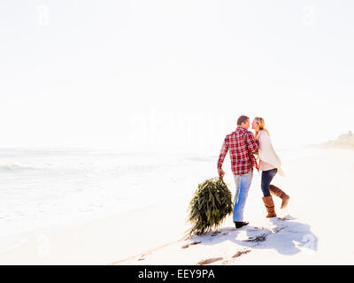 USA, Floride, Jupiter, Loving couple walking on beach with tree Banque D'Images