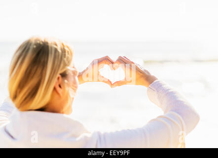 Femme montrant avec les mains en forme de coeur Banque D'Images