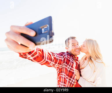 Couple on beach selfies Banque D'Images
