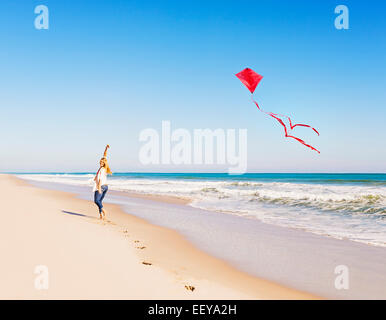 USA, Floride, Jupiter, Woman on beach with kite Banque D'Images