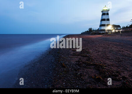 Canada, Nouveau-Brunswick, Île du Prince Édouard, allumé le phare de West Point vu de plage vide Banque D'Images