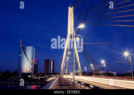La Lettonie, Riga, pont suspendu avec des gratte-ciel sur fond de nuit Banque D'Images