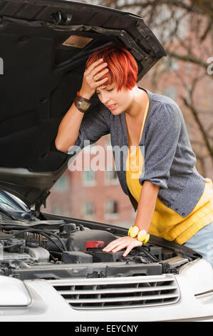 Femme frustrée à sous le capot de voiture Banque D'Images