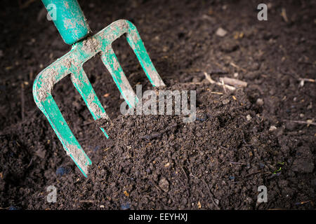 Tourner la fourche de jardin compostés en noir du sol bac à compost prêt pour le jardinage, Close up. Banque D'Images