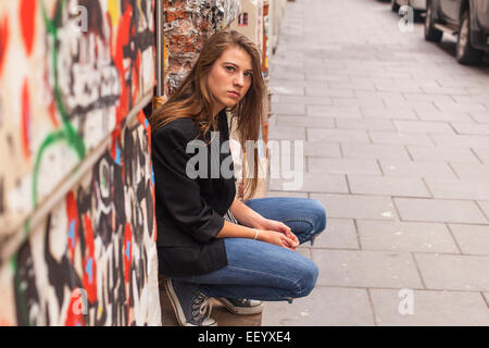 Hipster girl sitting dans la rue. Banque D'Images