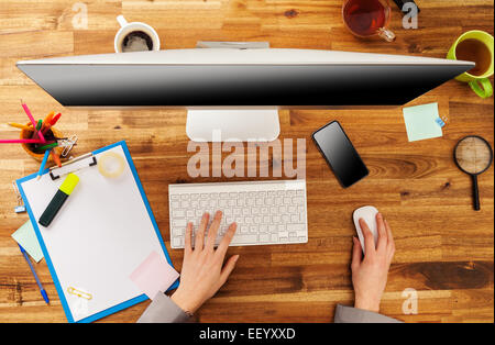 Femme travaillant avec l'ordinateur placé sur le bureau en bois. Prise de vue aérienne Banque D'Images