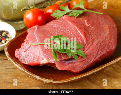 La viande de boeuf cru frais avec du poivre et des herbes sur plaque de bois Banque D'Images