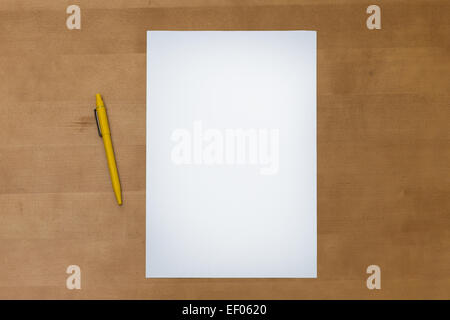 Stylo et une feuille de papier blanc sur une surface de table en bois, vue d'en haut Banque D'Images